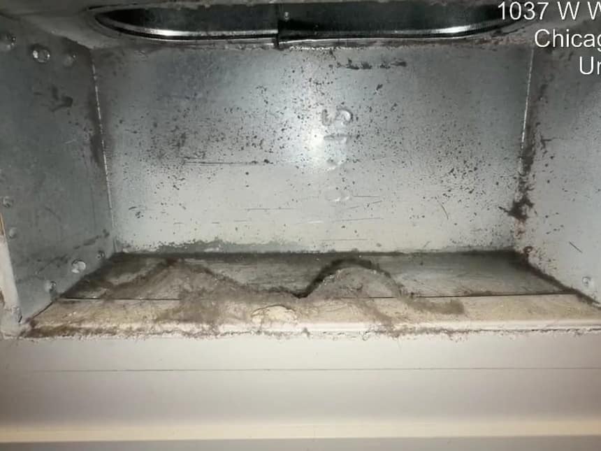 The inside of a rectangular sheet metal trunk duct after cleaning, bare metal with the seams visible