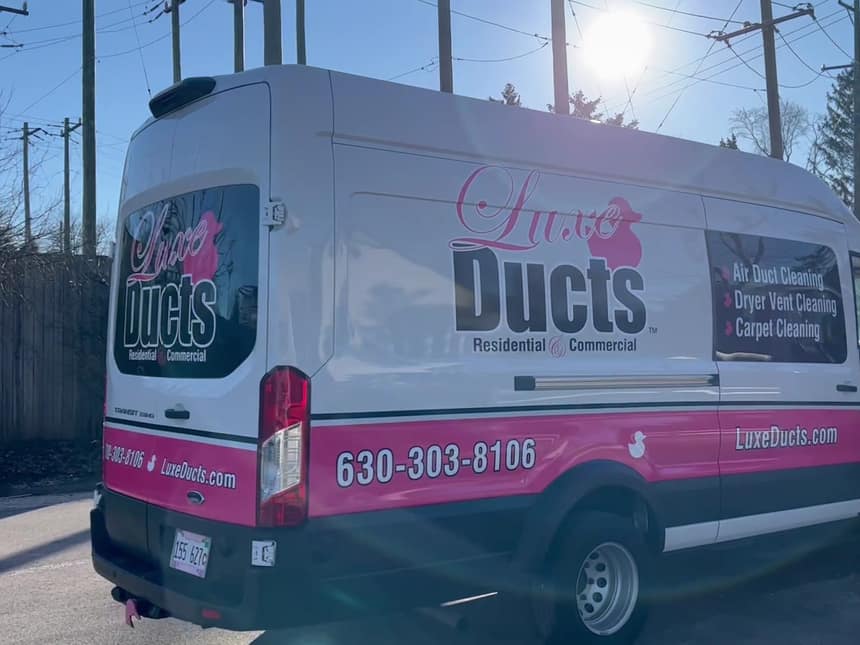 The Luxe Ducts van parked in a Chicago alley with the phone number and website across the back